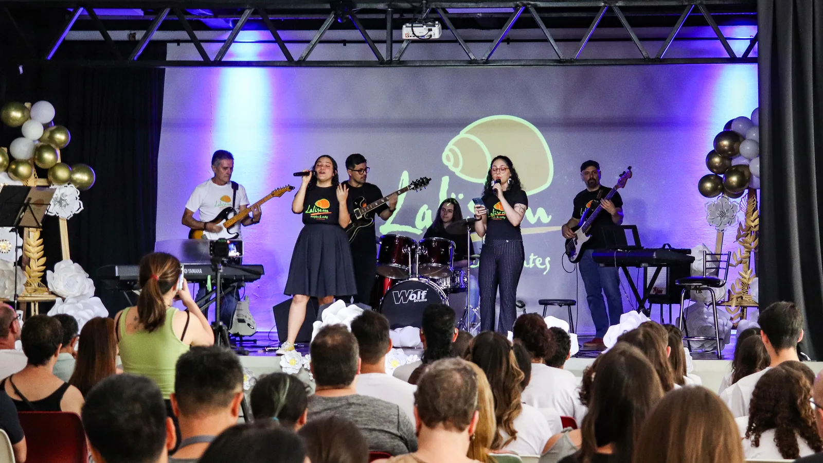 Apresentação de alunos da Lalisom no palco da escola